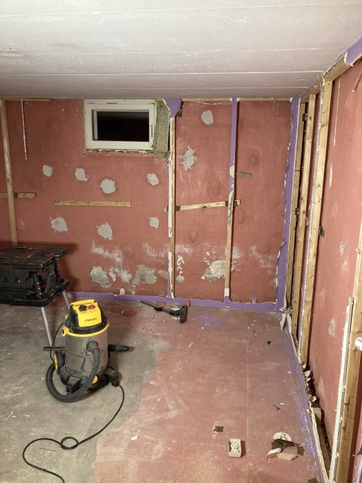 Renovering av källare med slipade väggar och gipsbruk, påbörjad klinkersläggning, golv- och väggsug finns med.