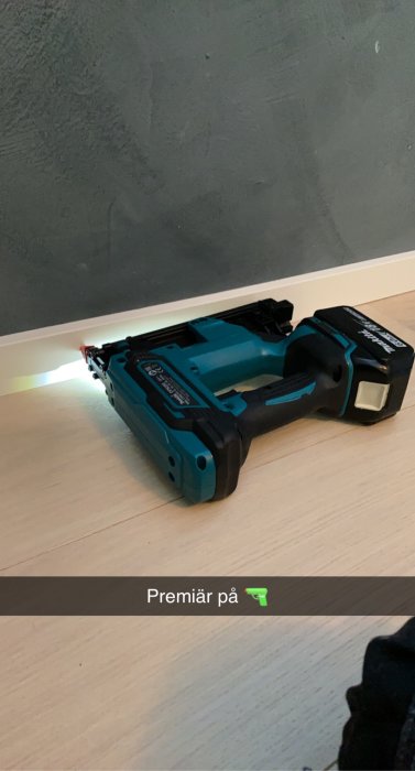 Makita dykpistol på ett golv med en text som lyder "Premiär på".