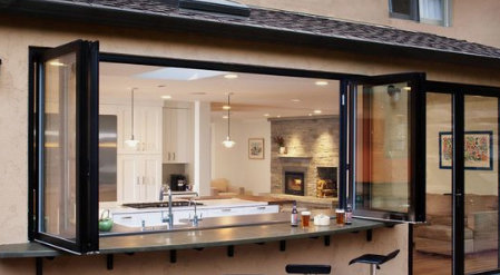 Kök med öppningsbara fönster som vetter mot ett inglasat uterum.