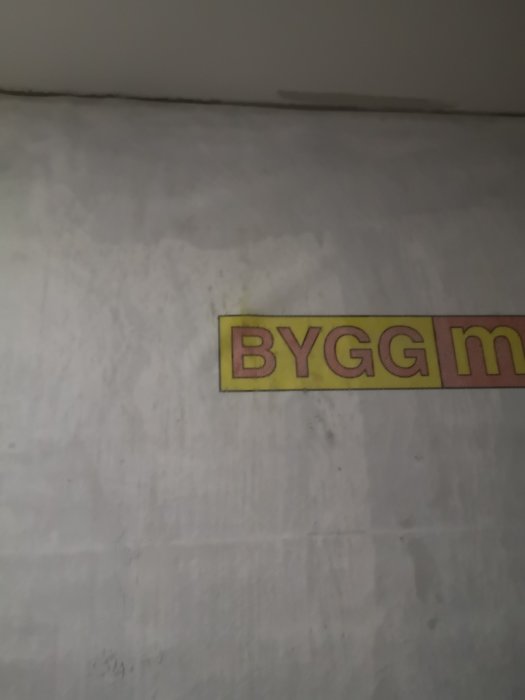 Oslaggyntad vägg med märkning "BYGGm" nertill, indikerar ett pågående bygg- eller renoveringsprojekt.