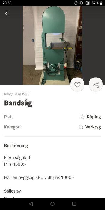 Grå bandsåg med grön fot och arbetsbord, använd i verkstadsmiljö.