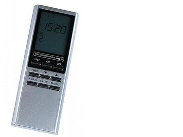 Silverfärgad TMT-502 fjärrkontroll med två batterier, display som visar klockan 15:20 och flera knappar.