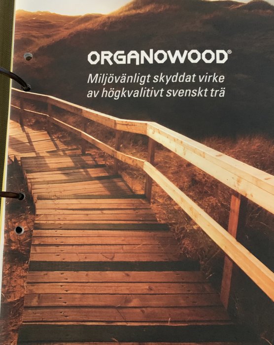 Organowood reklambroschyr som visar ett trädäck av skogsvirke längs en kulle, marknadsfört som miljövänligt och högkvalitativt.