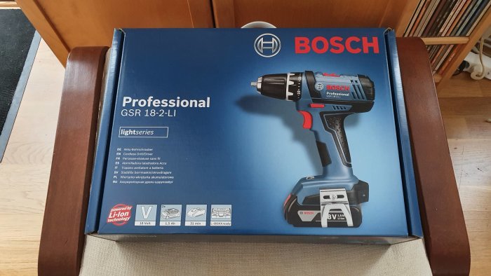 En Bosch Professional GSR 18-2-LI skruvdragare i förpackning på en stol.