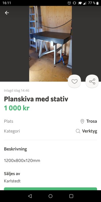 Arbetsbänk med tjock svart planskiva och vitt stativ i en verkstadslokal.