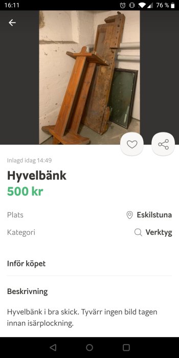 Hyvelbänk av trä står mot en vit vägg, använd för snickeri, i begagnat skick.