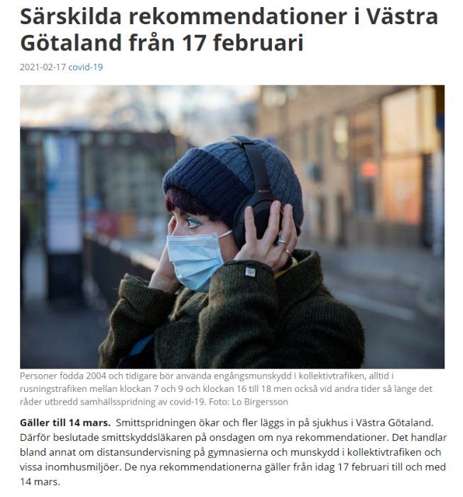 Person med munskydd och hörlurar på gatan, kontext om rekommedationer för munskyddsanvändning.