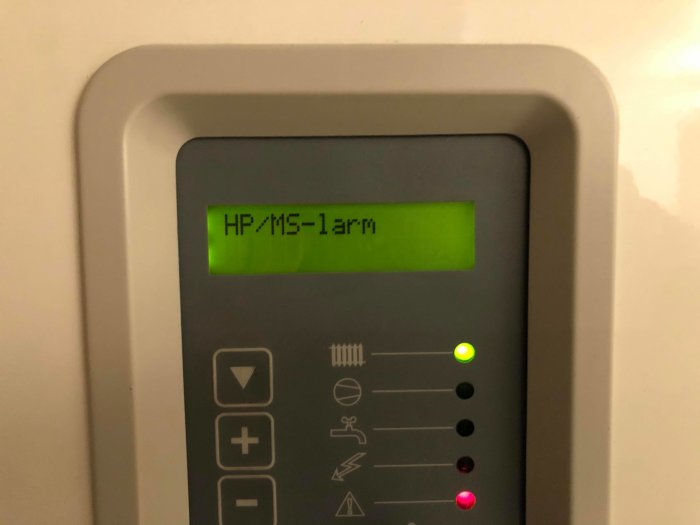 Panel på värmepump NIBE Fighter 1215 med HP/MS-larm på display och lysande statuslampor.