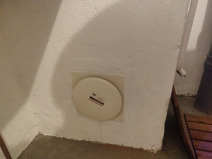 Ventilationsgaller i en vitmålad källarvägg vilket kan vara del av ett FTX-system.