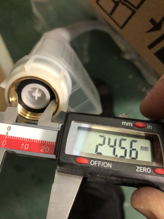 Skjutmått visar måttet 24,56 mm på ett rördel av en tvättmaskin för att illustrera R25-anslutning.