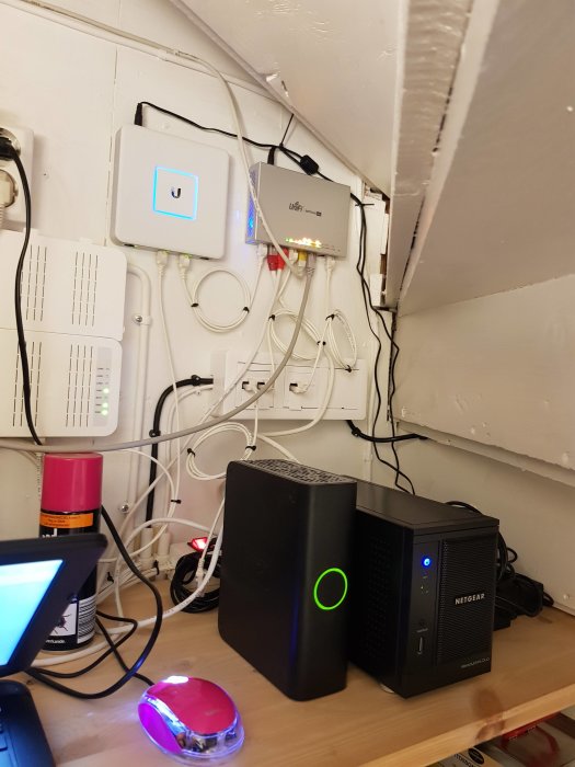 Installation av nätverksutrustning med switch, accesspunkt och kablar på en vägg.