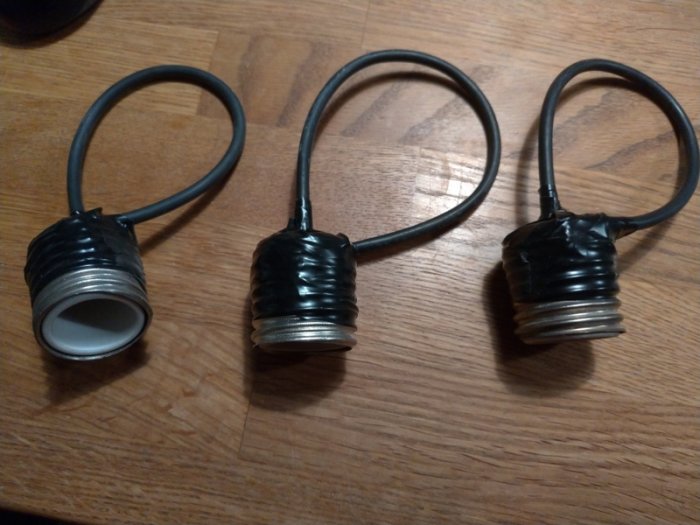 Tre G3 propphuvar med svarta elkablar och isoleringstejp på en träyta.