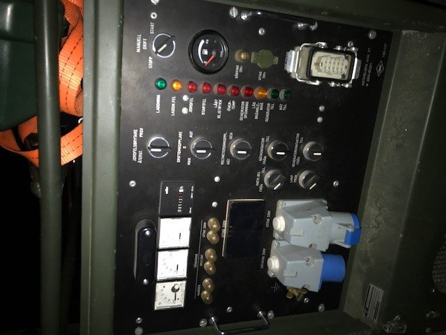 Bild på ett militärt elverk med panel, spänningsregulator, kontrollampor och Harting-don.