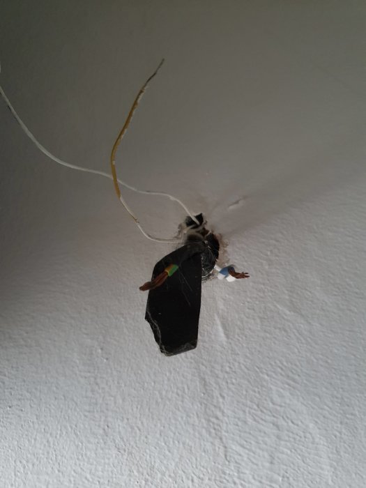 Öppen elinstallation i tak med synliga kablar avsedda för anslutning av en ringklocka.