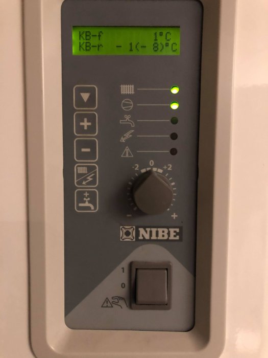 NIBE värmepumpspanel som visar temperatur och inställningar, med grön belyst display och reglage.