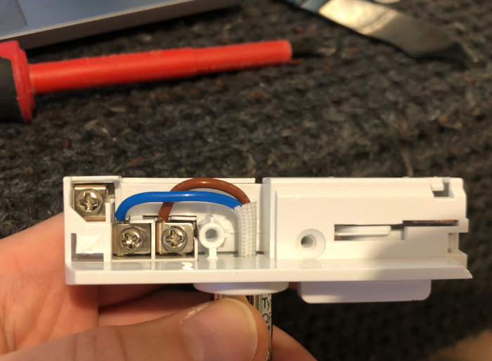 Öppen lampanslutning med synliga skruvanslutningar och kablar, som visar den nya adapterplattan och standardfästet.