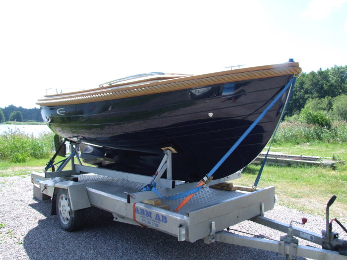 Svart 17-fots holländsk snipa på trailer, klädd med teakdäck, kallad "Grodan", av C-Marine.