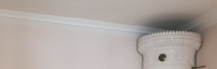 Takmålning som liknar grovt påförd spackel nära en utsmyckad takrosett.