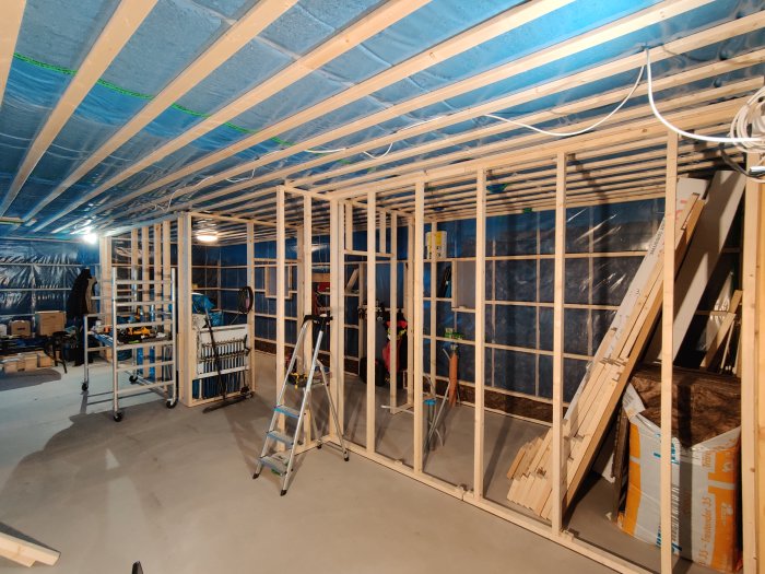 Innerväggar under konstruktion i ett byggprojekt, med synlig isolering och träreglar.