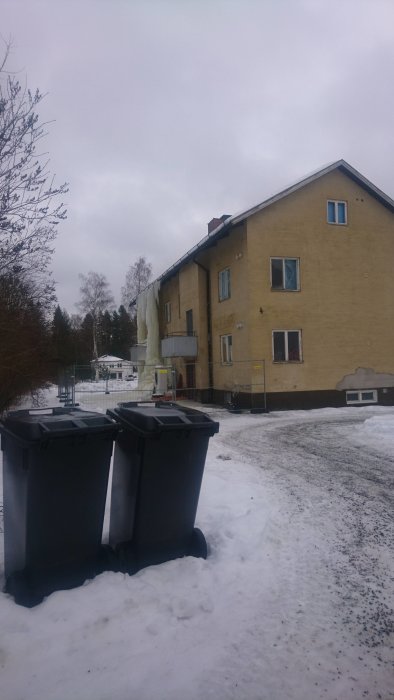 Hus i vintersäsong med stora isformationer längs fastighetens vägg och icke fungerande avlopp.