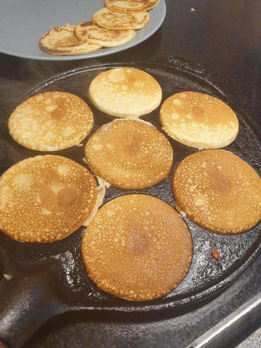 Stekta pannkakor på en svart stekpanna, redo för en barnvänlig lunch.