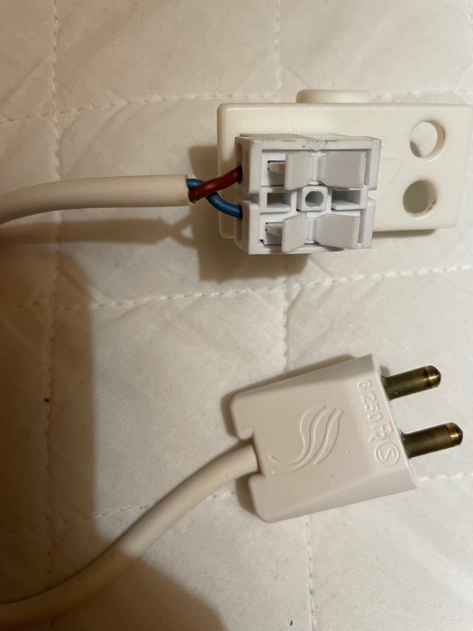 Adapter till IKEA-lampa med blå och brun kabel ansluten till en platt vit kontakt.