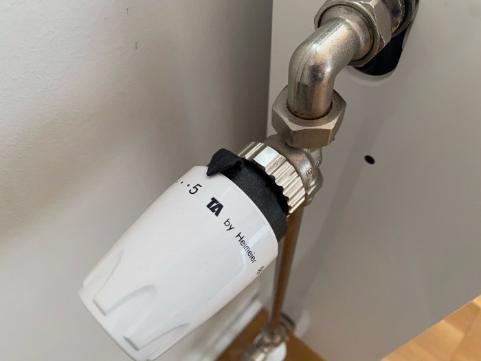 Termostat på radiator visar inställning nära max i ett radhus där värmen inte fungerar optimalt.