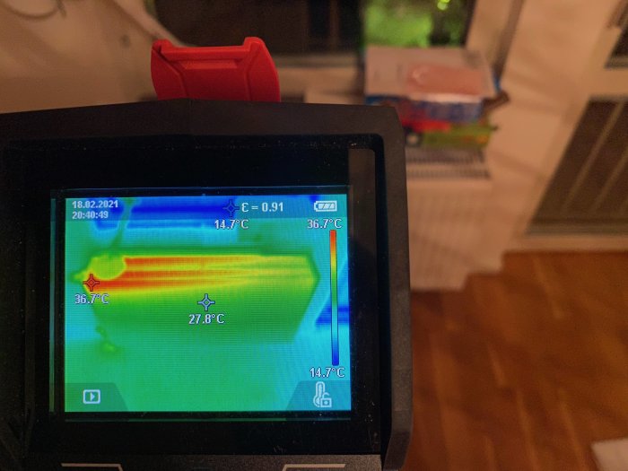 Värmekamerabild visar ett kallt element, temperaturer märkta på skärmen, i ett hus med fjärrvärme.