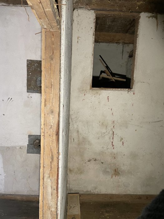 Vägg med en rektangulär öppning visandes silhuetten av en bakugn i ett gammalt rum.