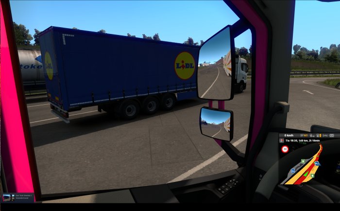 Bild från förarhytten i lastbil som visar en blå trailer med Lidl-logotyp på ett truck stop.