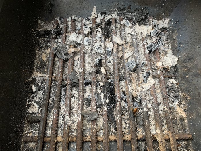 Använd grill med hemmagjort eldgaller av armeringsjärn, täckt av aska och halvbrända träbitar efter användning.