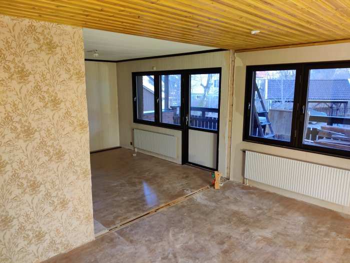 Renoverat rum med trägolv och tak samt borttagen vägg mot fönsterparti som ger öppet utrymme.