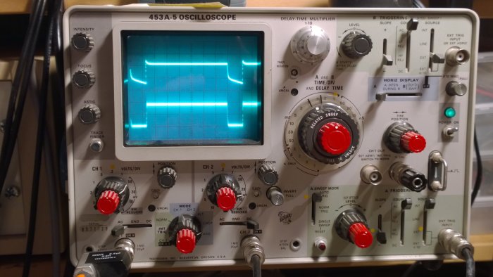 Oscilloskop som visar en vågform på skärmen, indikerande elektroniska tester eller mätningar.