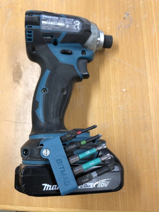 Makita borrskruvdragare med bithållare och färgkodade bits, inkluderande ett 2Ah batteri.