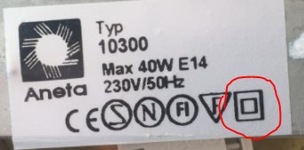 Etikett på lampa med tekniska specifikationer och symbol för dubbel isolering inringad i rött.