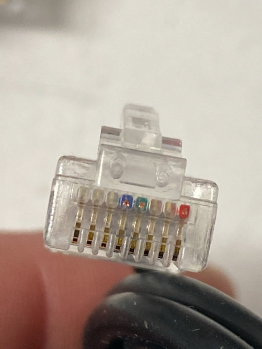 Närbild på en RJ45-kontakt med enbart tre anslutna ledare i en kabel.