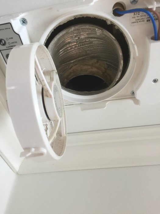 Badrumsvägg med öppen fläktinstallation utan anslutning till ventilationsspirorör.