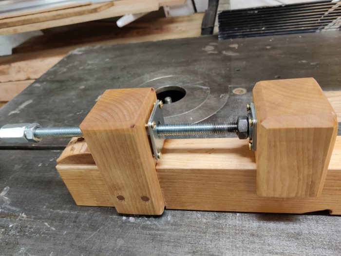 Handgjord limknekt av björk med M10-fingängad metallstång, oljad med linolja, på en arbetsbänk.