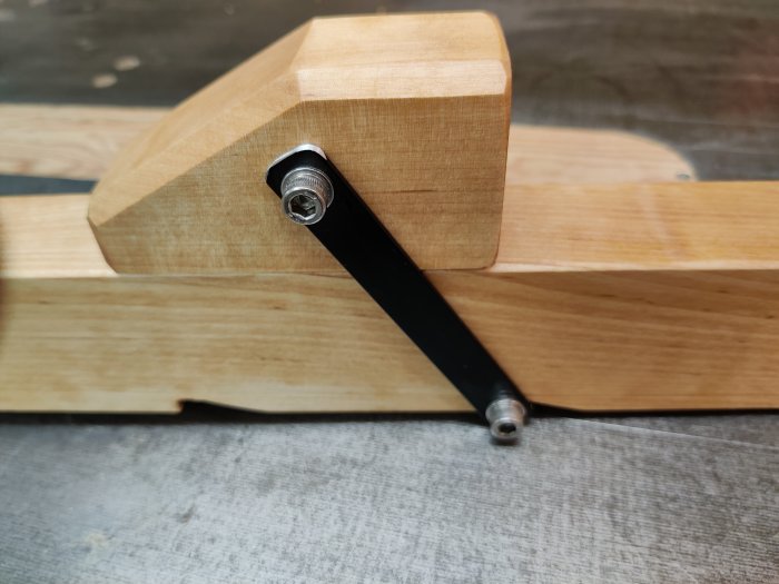 Hemgjord limknekt av björk med M10 metallgänga, oljad med linolja, på en träplatta.
