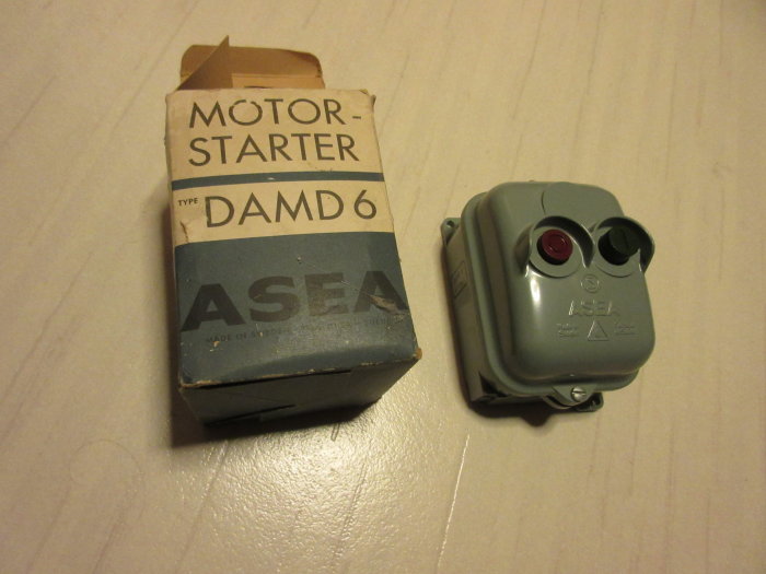 Oanvänd ASEA motorstarter DAMD6 bredvid sin gamla förpackning på ett bord.