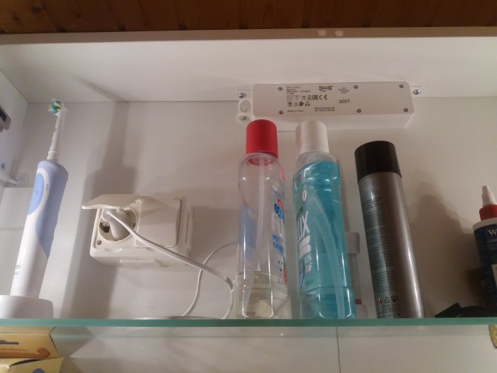 Hylla med badrumstillbehör och ett synligt drivdon från Ikea, lätt att byta enligt diskussionstråden.