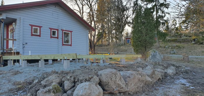 Nyinstallerade bärlinor på betongplintar vid ett husunderbyggnad.