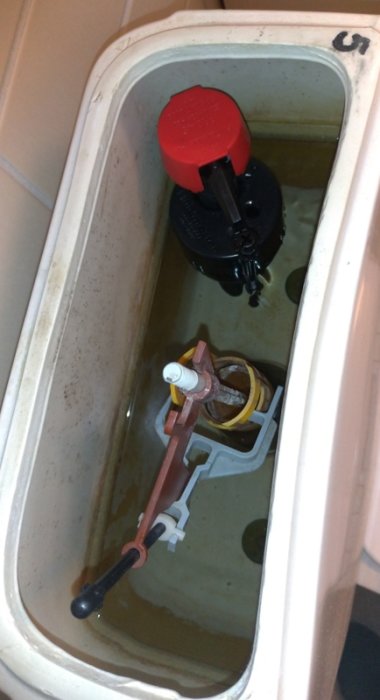 Inredningen i en toalettstol med en nyinstallerad fluidmaster och en orenad tank.