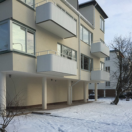 Funkishus från 1930-talet med nyligen byggd balkong och snötäckt mark.