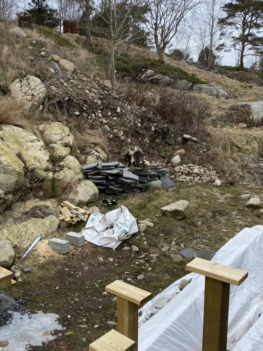 Oredigt byggområde med stenar, byggmaterial och en stubbe som refereras i texten.