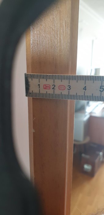 Mätning av dörrtjocklek med måttband visar 35mm på en HSB-dörr från 60-talet.