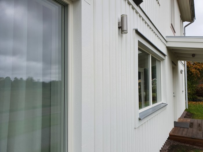 Vit husfasad med fönster och utrymme för Sunoff "Micro" markiskassett.