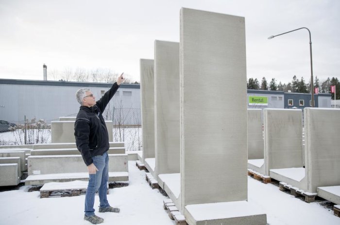 Person pekar på högt uppställda betongelement i olika storlekar utomhus.