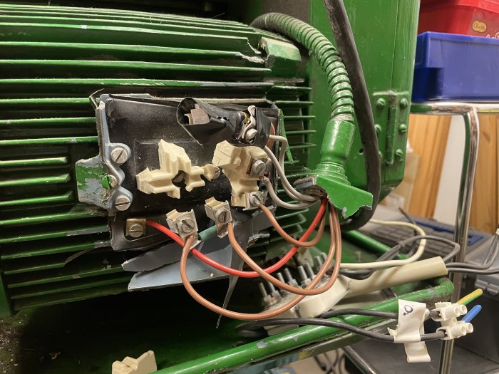 Skadad eldosa på grönt maskinverktyg med brytare och kablar, behov av rengöring och förmodad reparation.