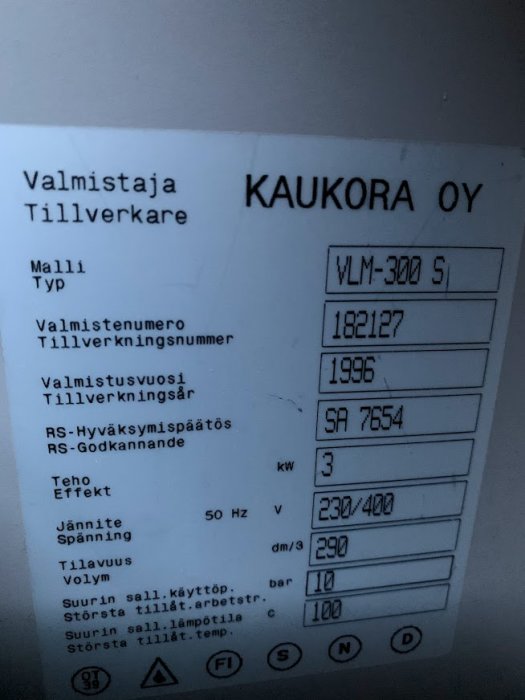 Etikett på en Kaukora Oy varmvattenberedare som visar modell, tillverkningsår 1996 och tekniska specifikationer.